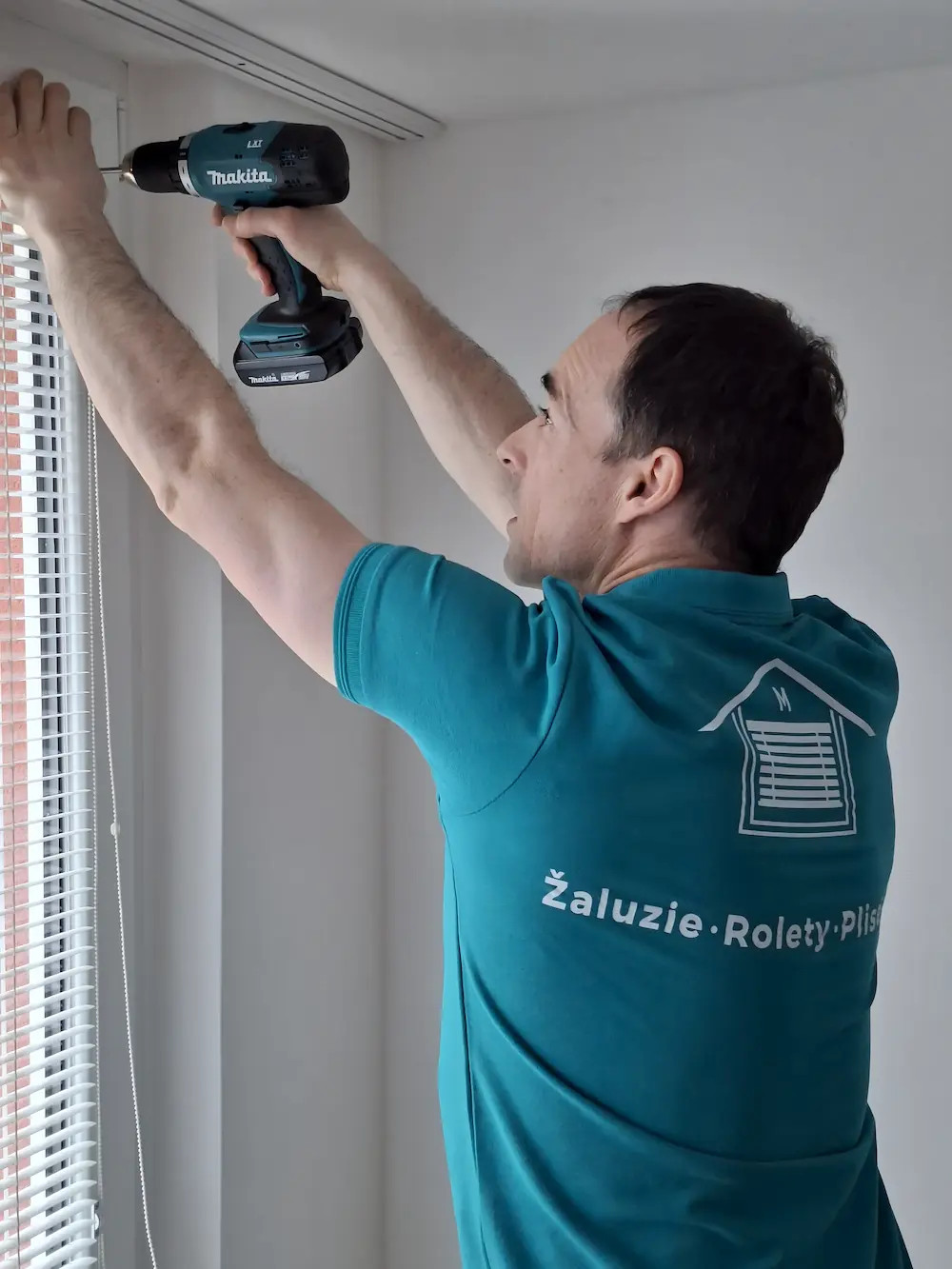 Karel Maroušek při montáži stínicí techniky v typickém bytě v Praze