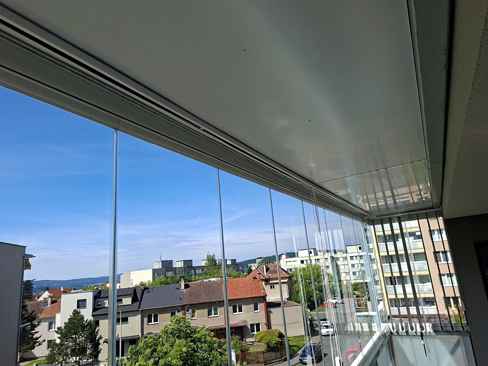 Horní kolejnice vertikálních žaluzií na zasklené lodžii